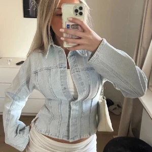 Ljusblå figursydd jeansjacka - Säljer en ljusblå jeansjacka med markerade sömmar och klassisk krage. Jackan har lång ärm och knäppning framtill. Pruta gärna❣️
