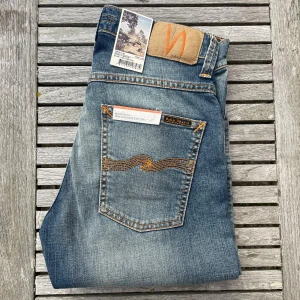 Nya Nudie Jeans Grim Tim - Säljer du dessa otroligt snygga Nudie jeans! De är storlek 28/32 och modell Grim Tim. Helt sprillans nya med tags, alltså helt oanvända! Sjukt snygg och unik tvätt, färg och stitching! Nypris är 1600 online! Hör av dig vid frågor och funderingar, priset är inte hugget i sten!