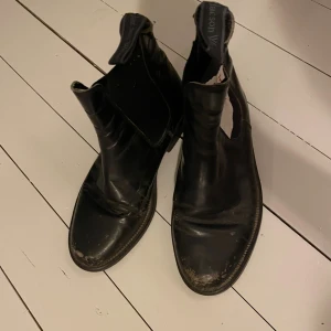Svarta chelsea boots i skinn stl 36 - Säljer ett par klassiska svarta chelsea boots från Jacson i äkta skinn. De har elastiska paneler på sidorna. I stolek 36 lite slitna på framsidan ( se bild ) men förutom det är dom hela från topp till tå 