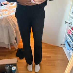 Svarta kostymbyxor från BikBok - Svarta kostymbyxor från BikBok i bootcut modell. Byxorna har medellåg midja, bälteshällor och diskreta fickor fram. Snygg passform med bootcut ben som ger en stilren look. Perfekta till en dressad outfit. Säljer då de är för korta för mig men har köpt nya då jag verkligen gillar modellen. Som nya och köpta för 500kr💕💕