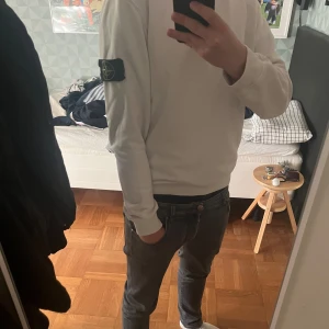 Vit sweatshirt från Stone Island - Vit sweatshirt från Stone Island med klassisk rund hals och ikonisk logga på vänster ärm. Tröjan har en clean look med ribbade muddar och är tillverkad i mjuk bomull. Liten färg defekt på axeln. Storlek M passar även S. Kom gärna med prisförslag till denna!✌️