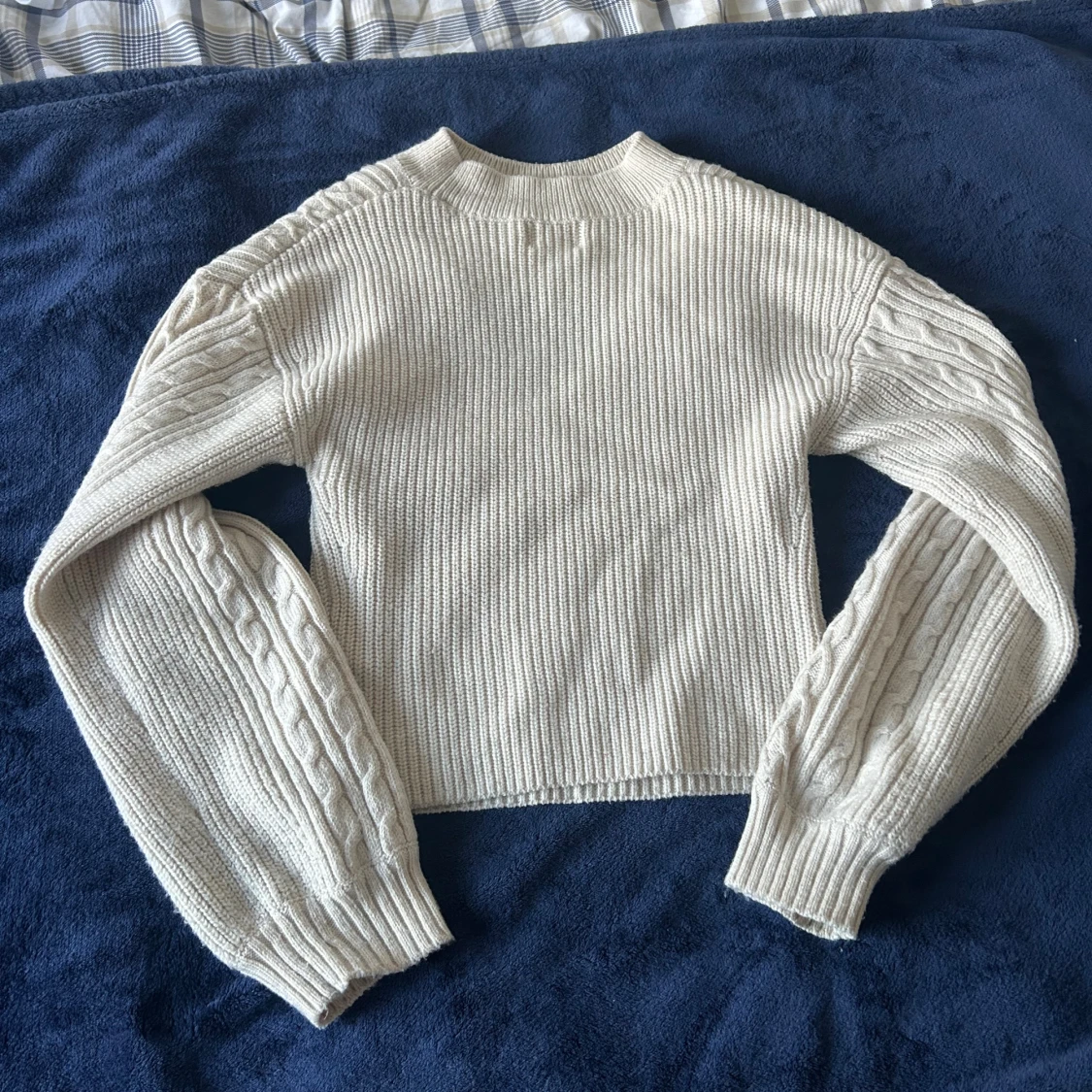 Beige stickad tröja med kabelmönster