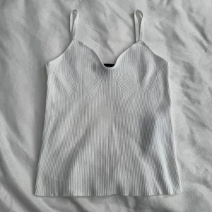 Vitt linne från Vero Moda - Ribbstickat linne från Vero Moda i storlek S. Smala axelband & v-ringad hals. Aldrig använt. Fraktar inom 24h!