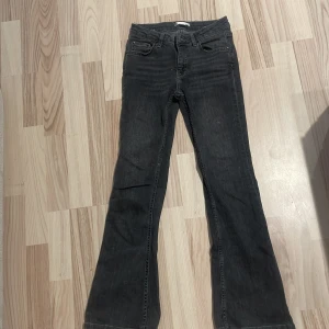 Svarta bootcut jeans från Gina Tricot - Snygga svarta jeans från Gina Tricot med bootcut-modell. Jeansen har klassisk femficksdesign, normalhög midja och är tillverkade i mjukt denimtyg. Perfekta för dig som gillar en tidlös look med lite utsvängda ben.