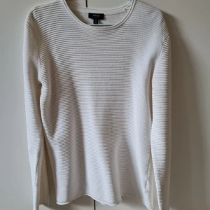 Vit ribbad tröja från SMOG (New Yorker) strl M - Vit långärmad tröja från SMOG (New Yorker) i slim fit-modell. Tröjan har ett ribbat, horisontellt mönster. Material bomull och polyester. Storlek M.