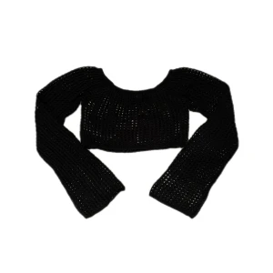 Svart croppad stickad topp Urban Outfitters - Säljer en svart croppad stickad topp från Urban Outfitters. Toppen har långärmade ärmar och är tillverkad i ett grovmaskigt stickat material som ger en cool och edgy vibe. Perfekt för att styla med gulliga jeans eller kjol.
