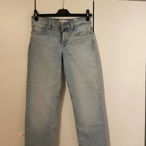 Ljusblå raka jeans från Zara - Ljusblå jeans från Zara med raka ben och klassisk femficksmodell. Jeansen har hög midja och stängs med knappar framtill. Tillverkade i bomull för en skön och avslappnad känsla.