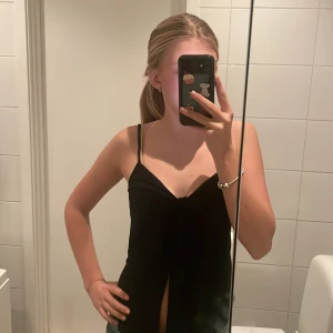 Svart linnetopp från Gina Tricot - Svart topp från Gina tricot. Toppen har en snygg knytning framtill som skapar en liten slits. 