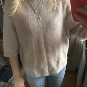 Beige stickad tröja med trekvartsärm - Mysig beige stickad tröja med rund hals och trekvartsärmar. Tröjan har en loose passform och är tillverkad i ett mjukt material som känns skönt mot huden. köpt för 790kr, super bra skick 💞💞💞