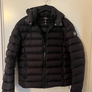 Colmar Jacka  - Svart dunjacka från Colmar med avtagbar huva.  Jackan är i bra skick (endast märket på ryggen som börjat lossna). Perfekt nu till vintern.