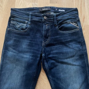 Mörkblå Replay Anbass W30 L34 - Jag säljer dom här riktigt fräscha Replay Anbass jeansen i storlek W30 L34. De är inte använda mycket alls och har inga skador eller defekter. Tveka inte att höra av er!                                         Mått: Längd=106cm. Midja=40cm