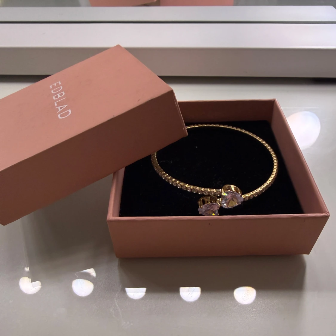 Guldfärgat armband med hjärtformade stenar