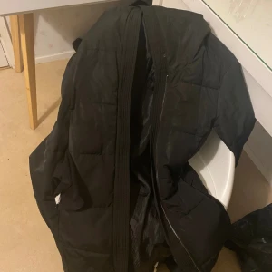 Svart pufferjacka från Anna Field - Svart Anna field lång vinterjacka, jackan är på bra skick men högra fickan är sönder därav priset, köptes för 1 år sedan. Jackan har 2 dragkedjor. Väldigt varm och perfekt till vintern. Köptes för 1000 kr. PRIS KAN DISKUTERAS VID SNABB AFFÄR