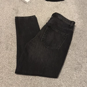 Zara jeans  - Säljer ett par svarta jeans med lätt tvättad look och klassisk femficksdesign. Jeansen har raka ben, bälteshällor och dragkedja med knapp framtill. Perfekta för dig som gillar en stilren och enkel vibe.