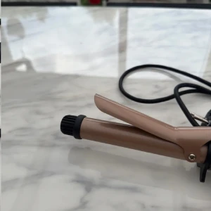 Emerio Locktång - Emerio locktång i fint skick. Perfekt för att skapa vackra lockar och vågor. Enkel att använda med on/off-knapp och snabb uppvärmning. Sladd och kontakt i bra skick, inga synliga defekter eller slitage. Passar både vardag och fest.