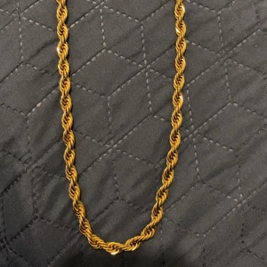 18k Guldplaterad Cordell halsband 60 cm - Snyggt halsband i guldplaterad metall med tvinnad kedja och robust karbinlås. Kedjan är ca 60 cm lång och har en chunky känsla som sticker ut. Perfekt för dig som gillar statement-smycken med lite extra edge rost fritt stål.