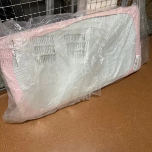  Rosa Barn Madrass  - Produkten på bilderna är en madrass eller dyna, troligen för barn eller baby som är rosa. Den är förpackad i plast och är oanvänd.