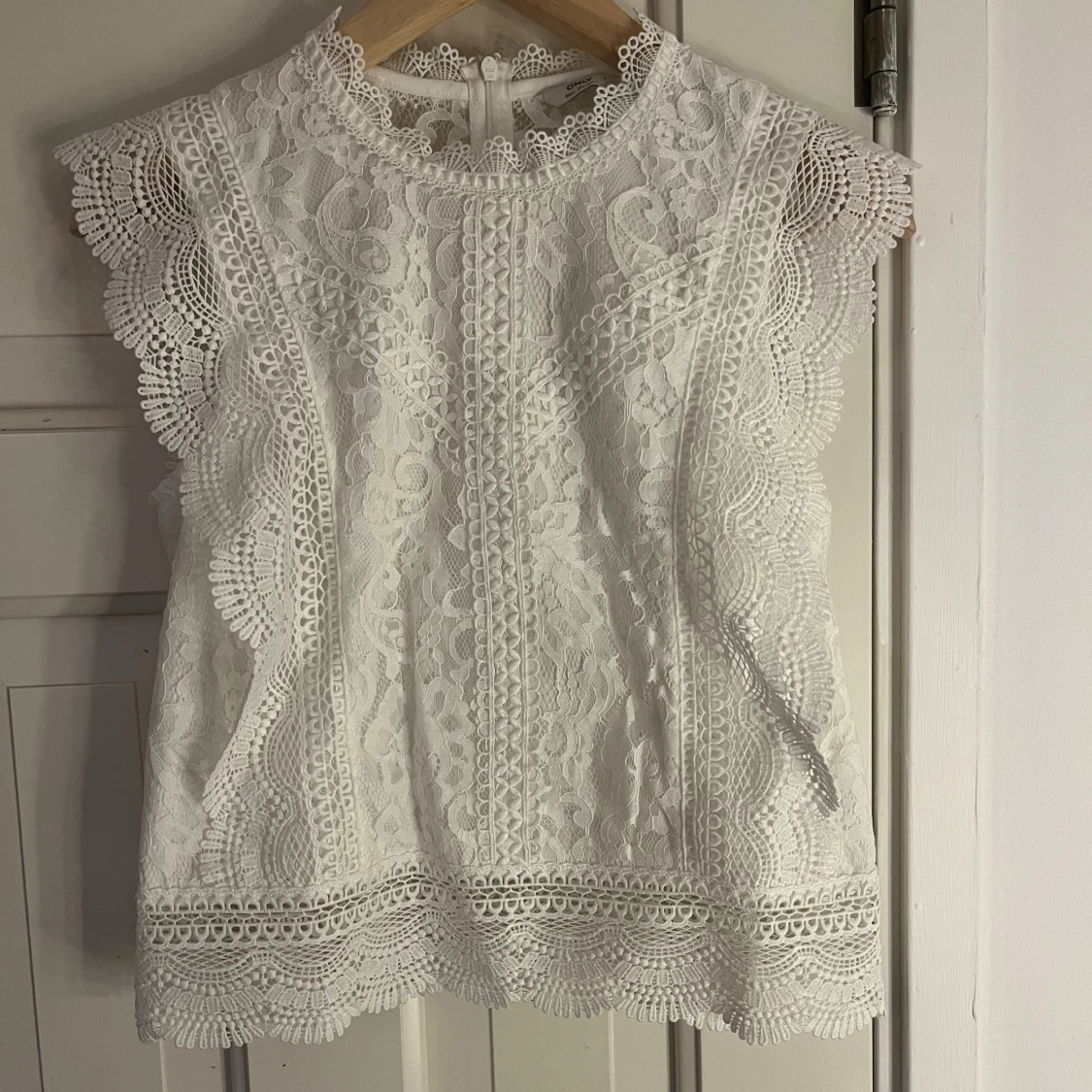 Vit spetsblus med volangdetaljer