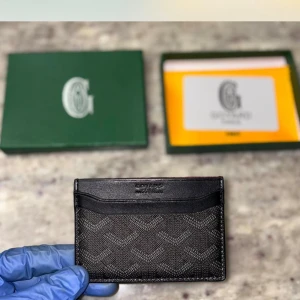  Goy4rd plånbok  - Slimmad svart plånbok från Goy4rd med ikoniskt mönster och rödfärgad insida. Tillverkad i exklusivt skinn med flera kortfack och stilren design. Perfekt för dig som vill ha något både snyggt och praktiskt i fickan.