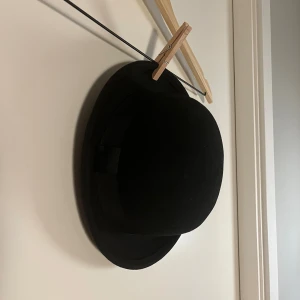 Svart ullhatt från H&M Divided - Klassisk svart hatt i ull från H&M Divided. Hatten har rundad kulle och smal brätte, samt ett diskret band runtom. Perfekt accessoar för att lyfta din stil med en tidlös och cool touch.