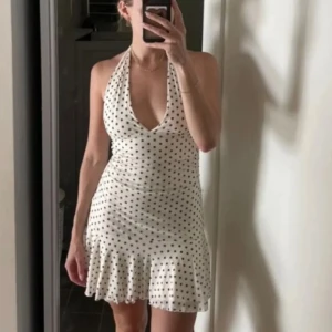 Klänning  - Superfin Cremevit halterneck klänning med svarta pricka, volang nertill, storlek S🤍