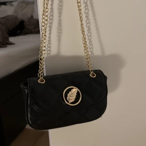 IOAKU väska från adventskalender 2025 guld - Aldrig använd , säljer då det inte riktigt är min stil dock en väldigt fin väska 