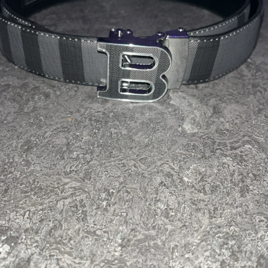 Randigt svart bälte med B-spänne