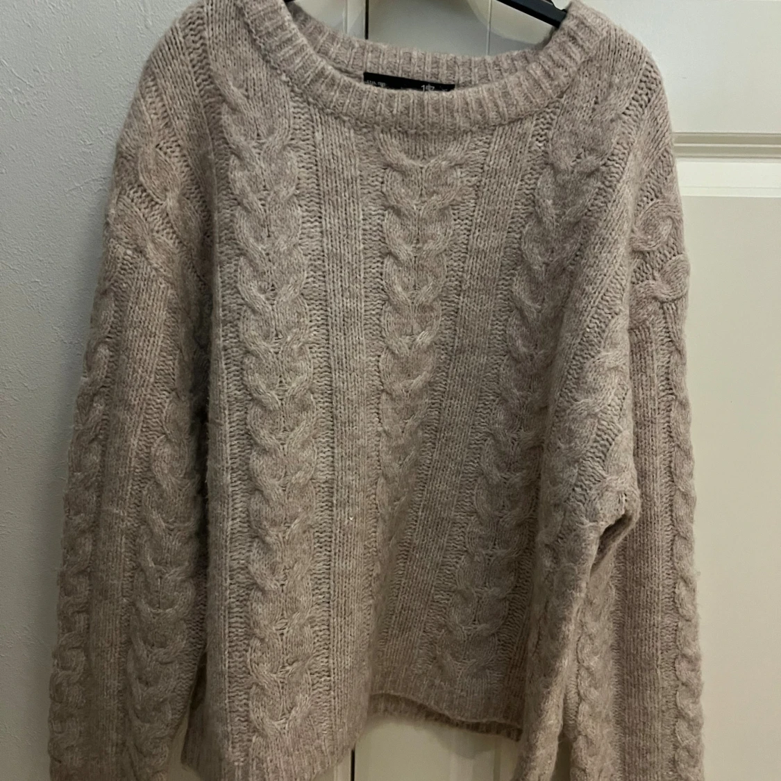 Beige stickad kabeltröja