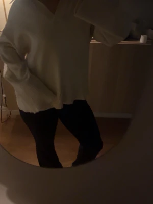 Vit oversized stickad tröja - Säljer en vit oversized stickad tröja med v-ringning och breda ribbade muddar. Tröjan har lång ärm och en avslappnad passform som ger en chill vibe. Perfekt att slänga på sig när det är kallt ute.