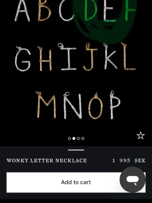 Maria Nilsdotter halsband - Maria Nilsdotter halsband med ett snett bokstavshänge i ett E i silver. Kedjan är tunn och stilren, perfekt för att bära din favoritbokstav runt halsen. Designen är lekfull och modern, vilket gör smycket till en cool detalj i din look.