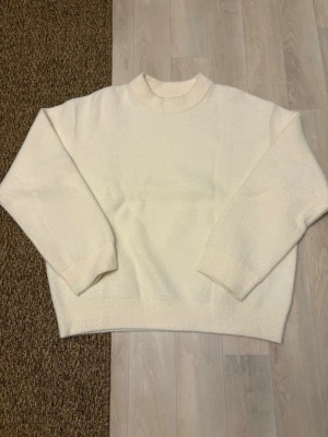 Krämvit stickad tröja från Zara - Mysig krämvit stickad tröja från Zara med rund halsringning och avslappnad passform. Tröjan är helt ny och har ej använts.