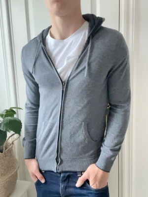 Massimo dutti full zip / cardigan.  - Den skönaste passformen du kan tänka dig har denna Massimo dutti full zip / cardigan, som passar perfekt på modellen som är 180 cm 75 kg och bär storlek S. Det är väldigt många fina detljaer på tröjan som tex finns det ett annat material i luvan, två fickor, en annan färg i slutet av tröjan som gör den mer clean. En av våra favoriter just nu! 