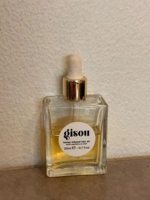 Gisou honey infused hair oil 20 ml  - Säljer en lyxig hårolja som gått viralt från Gisou med honungsextrakt. Kommer i en elegant, fyrkantig glasflaska med pipett och guldfärgat lock. Innehållet är gyllengult och flaskan rymmer 20 ml. Perfekt för att ge håret extra glans och näring. Har använt lite av den, så det är lite mer än halva kvar! 