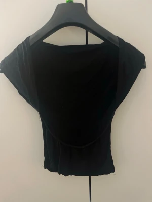 Svart T-shirt med öppen rygg - Snygg svart T-shirt med en öppen rygg 