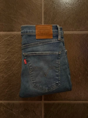 Levi's Mile High Super Skinny jeans - Snygga blå Levi's Mile High Super Skinny jeans med klassisk femficksdesign och hög midja. Jeansen har en tajt passform hela vägen ner och är tillverkade i mjukt denim med stretch för extra komfort. Perfekta för dig som gillar en slimmad siluett.