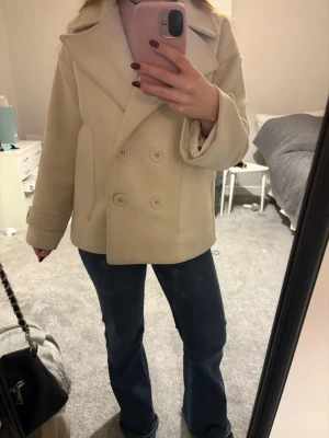 Krämvit kappa - Superfin kappa perfekt till våren! Säljer för att den inte kommer till användning längre. 