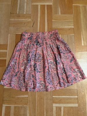 Blommig kortkjol från H&M - Söt kortkjol från H&M i en rosa nyans med blommigt mönster. Kjolen har resår i midjan och är gjord i mjuk bomull. Använd kanske 2-3 ggr. Så nyskick 