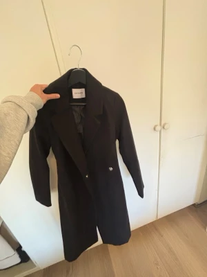 Svart lång kappa - En svart helt oanvänd svart kappa