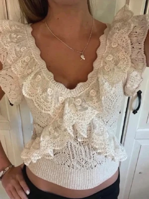 Beige spetsig Zara volangtopp med v-ringning - Supersöt beige topp med v-ringning och volanger i spets. Den är nästan intill helt nytt skick och sälj inte längre av Zara. 