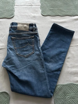 Jacob Cohen J622/Nick - Äkta Jacob Cohen-jeans, modell 622 / Nick, tillverkade i exklusiv italiensk denim. Klassisk slim fit med mycket bra passform och komfort.  🔹 Storlek: W31 🔹 Skick: Utmärkt skick 🔹 Detaljer: – Ett professionellt lagat hål nedanför gylfen – i princip osynligt när de används – Ett litet lagat hål på insidan av vänster framficka (syns endast när fickan öppnas helt, fickan fungerar precis som normalt) – Inga andra defekter, fläckar eller överdrivet slitage  Meddela gärna för frågor/bilder och prisbud 