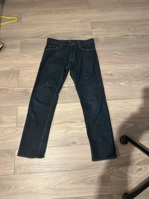 Mörkblå raka jeans från Levi's - Snygga mörkblå jeans från Hugo Boss med klassisk rak passform och femficksdesign. Jeansen har kontrastsömmar och är tillverkade i robust denim. Perfekta för dig som gillar en tidlös och clean look.