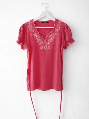 Rosa vintage blus med vit brodering & midjedetalj - En söt rosa vintage blus med vita blombroderi & snörning i midjan som detalj från märket time i storlek L. Snörningen knyter man antingen på framsidan eller baksidan. Den är köpt secondhand (för 150kr) men har aldrig kommit till användning. Den är i 100% Bomull. FÖRST TILL KVARN!