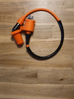 Tändspole med tändkabel orange - Säljer en recing tändspole med tillhörande tändkabel i orange och svart. Passar till moped eller scooter. Kabeln har en robust isolering och tändhatten är i plast. Perfekt för dig som vill byta ut eller uppgradera din tändsystem.