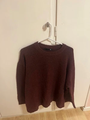 Stickad tröja  - En enkel och snygg mörkröd stickad tröja från Lager 157. Tröjan har rund halsringning, långa ärmar och är gjord i ett mjukt, lite luddigt material. Perfekt för lager på lager och passar till det mesta i garderoben.