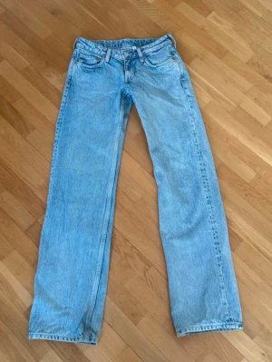 Weekday low waist straight jeans - Weekday jeans W25 L32 i ljusblå denim med rak passform och normal midja. Tidlös modell med fem fickor och knappgylf, perfekt för en avslappnad och cool stil.