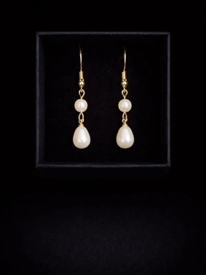 Guldörhängen med vita pärlor - Eleganta örhängen i guldton med två vita pärlor i olika former, en rund och en droppformad. Perfekta för att lyfta din stil med en klassisk touch. Säljs i svart ask.