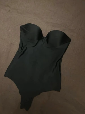 H&M- Body i mikrofiber med vadderade kupor - Hm  Body i mikrofiber med vadderade kupor  Stl. Lappen är bortklippt men sitter som XS Som ny. Knappt använd. (Banden följer inte med)  Pris kan diskuteras!!