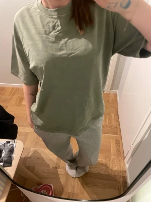 Grön oversized t-shirt Altered Club - Säljer en grön oversized t-shirt från Altered Club. T-shirten har korta ärmar, rund halsringning och en enkel logga tryckt på bröstet. Tillverkad i mjuk bomull som känns skön mot huden. Perfekt för en avslappnad och trendig look.