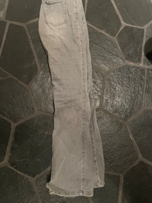 Gråa bootcut jeans  - Snygga grå jeans med bootcut-modell och rå, fransig kant nertill. Klassisk femficksdesign och normal passform. Perfekta för en avslappnad och trendig look. Nästan aldrig använda . 