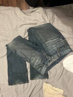 Vintage Jeans - Fina blåa vintage jeans i strl 32. (Skulle säga aningen uttöjda, XS/S). Något slitet nere vid hälarna och jeansen har ett hål vid insida lår (kolla bild). Sälja eftersom de är försmå för mig. 